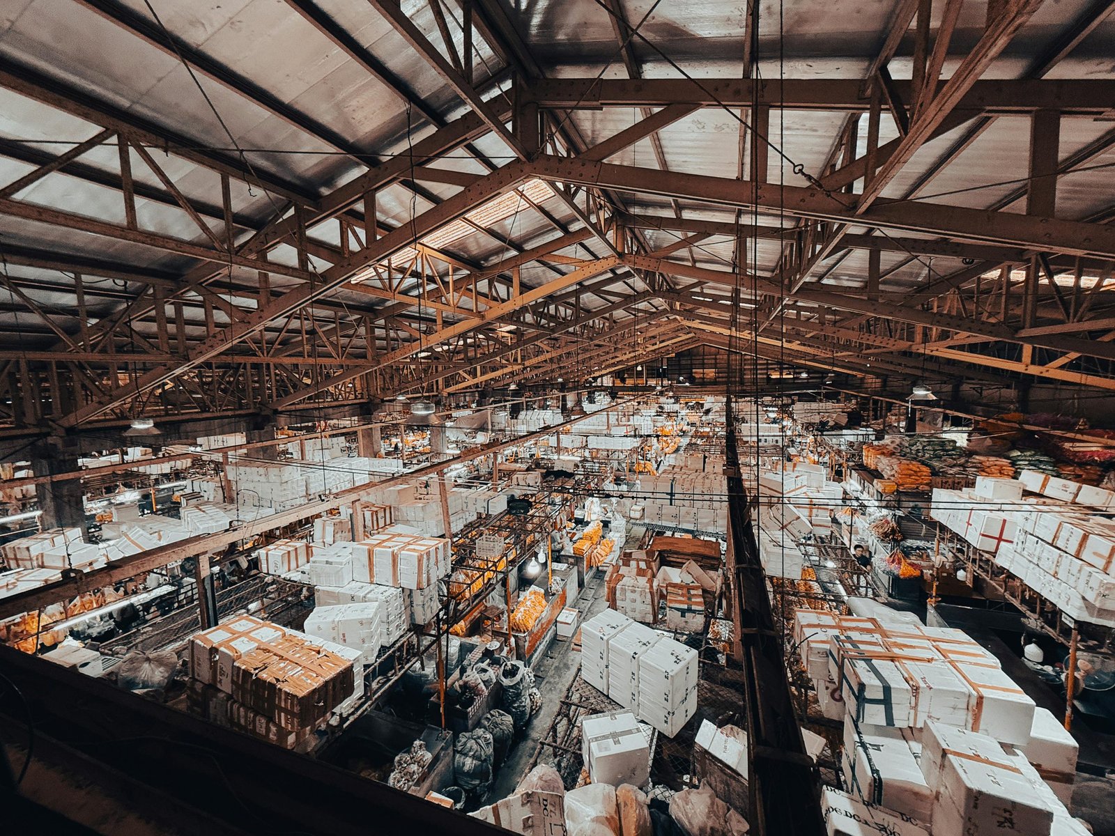 An aerial view of a vibrant indoor market with stalls in Bangkok, Thailand.