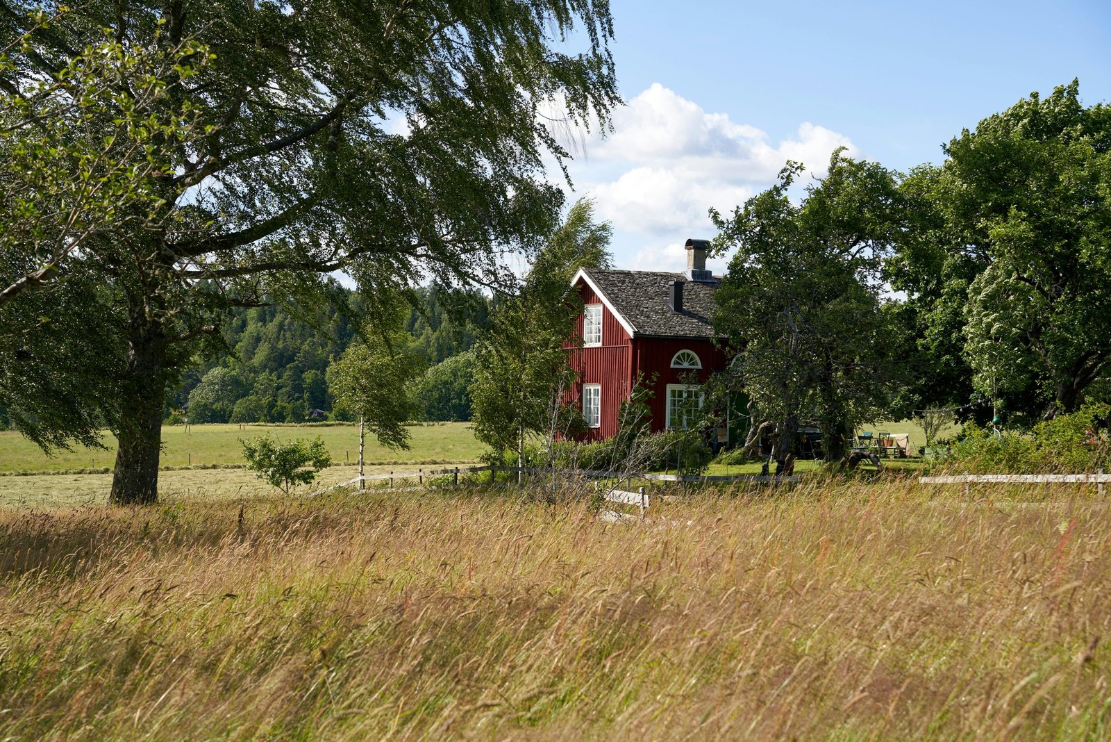 Rustic red house amidst lush greenery in Håverud, Sweden captured during summer.