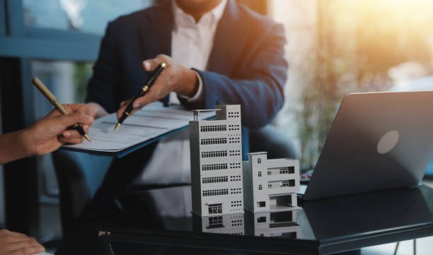 A businesswoman engaged in writing on paper, possibly outlining details for a commercial lending loan.