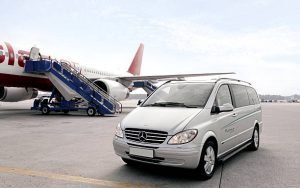 Vehicles traveling along the road, highlighting a private airport car service.