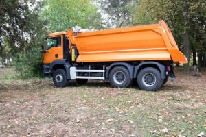 A large orange garbage truck parked, representing a dumpster rental service.