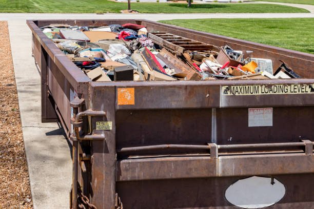 A fully loaded truck overalls carrying a cart loaded with boxes, part of a junk removal service.