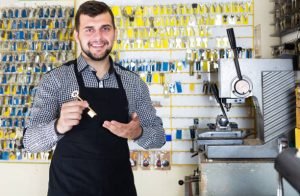A man holds a key in front of a lock, symbolizing the importance of hiring a local locksmith in Dearborn, MI.