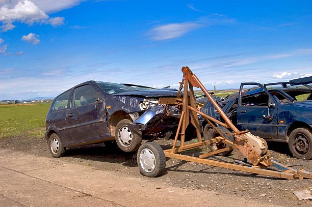 A collection of cars stacked atop one another at Reliable Auto Junkyard, Miami, illustrating vehicle disposal.