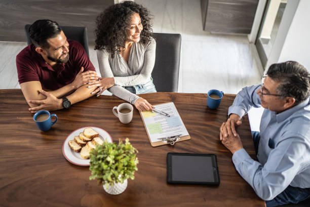  A man and woman are seated at a table, reviewing documents related to a money lending agreement.