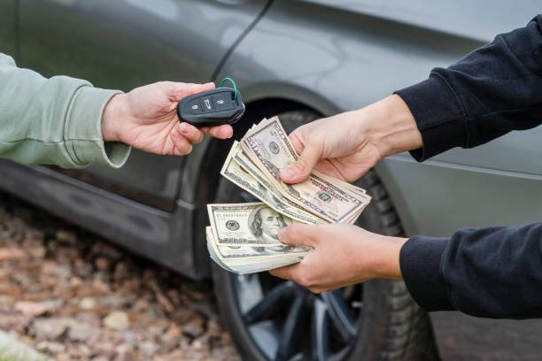A man displaying money in front of a car, encouraging viewers to sell their junk car for immediate payment.