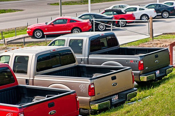 Several trucks lined up in a parking lot, available for buyers regardless of their credit status.