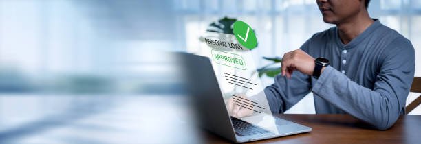 Man uses a computer to check approved personal loans from a bank or company that allows individuals or organizations to borrow money for business or personal expenses. Finance and investment.