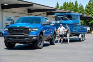 Two men converse beside a local used car and truck, discussing details while standing next to the vehicle.
