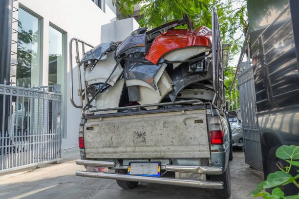 A man with a remote control stands next to a truck overflowing with junk, advertising electronic waste pickup in Franklin, TN.