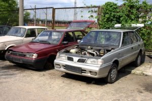A collection of parked cars in a lot, representing opportunities to sell to a scrap yard.