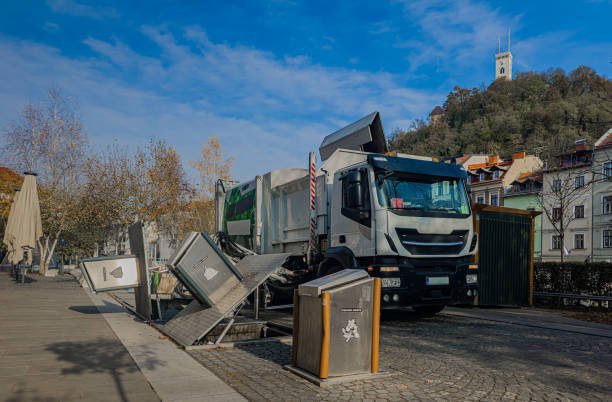 overalls carrying a cart loaded with boxes, part of a junk removal service.