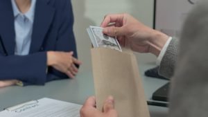 Businessman handing cash to another person, symbolizing a private funding loan transaction.