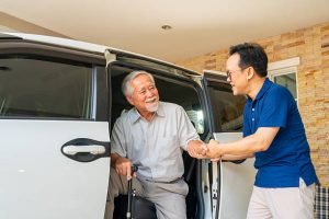 Inside a taxi, a man shakes hands with an older man, highlighting transportation for daily errands in Lake Havasu.