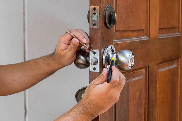 A person using keys to unlock a door, representing locksmith services in Bossier Parish, LA.