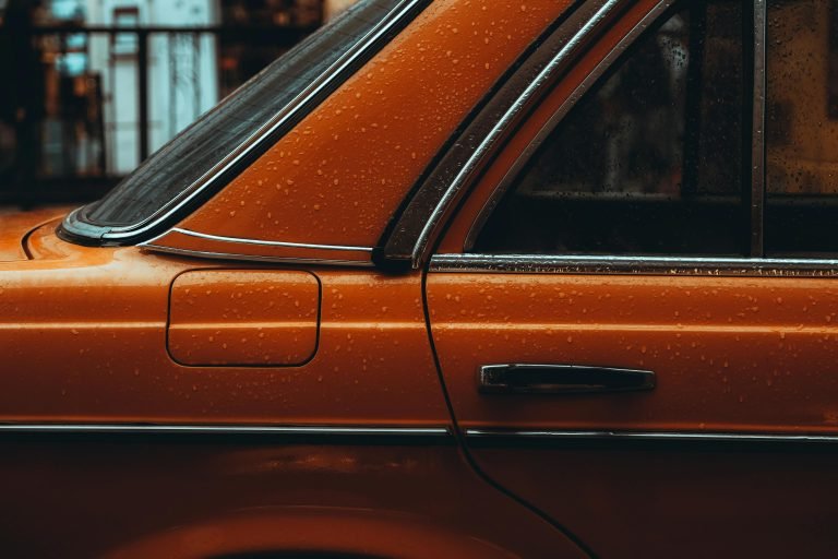 Capture of an orange vintage car with raindrops on the side in İstanbul.