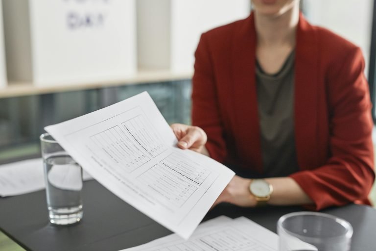 Close-up of a person handing over a business document during a meeting.