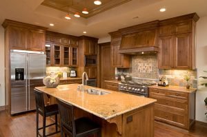Spacious kitchen with a central island and rich wooden cabinets, highlighting a stylish and functional cooking space.