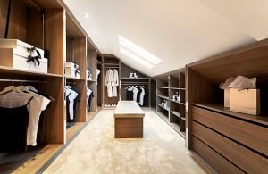 A luxurious walk-in closet illuminated by a skylight, featuring modern wood cabinets that enhance the space's appeal.