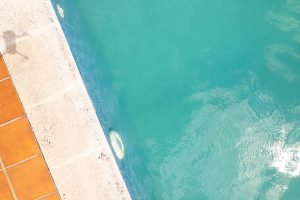 A pool with water and a wall nearby, serving as a visual for pool water leak detection scenarios.