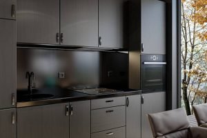 Stylish kitchen interior with modern cabinets and a large window that opens up to a beautiful outdoor landscape.