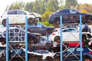 A collection of cars stacked vertically at a junkyard, showcasing the inventory in Canal Whitehall, Ohio.