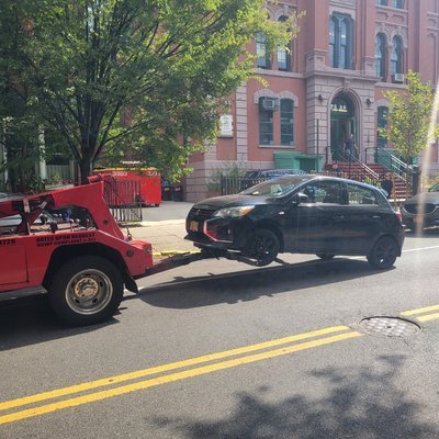 A tow truck parked on the roadside, advertising "Instant Cash For Cars" on its side.