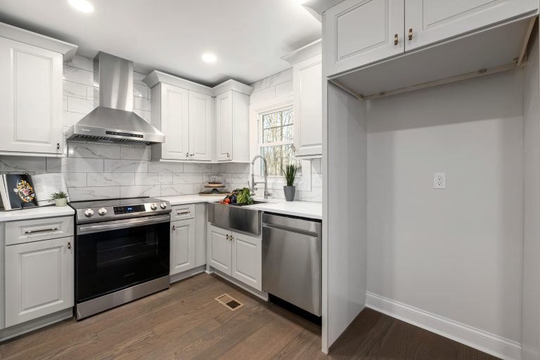 Bright, modern kitchen with stainless steel appliances and white cabinets in a minimalist style.