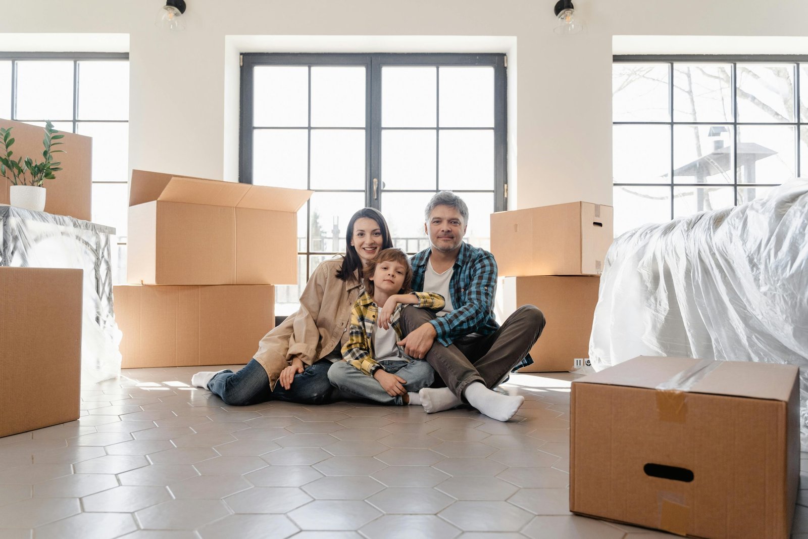 A joyful family sitting together amidst moving boxes, marking a new beginning in their home.