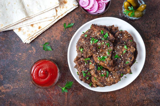 A dish featuring meat patties with tomatoes and lettuce, representing local flavors available near Edison, NJ.