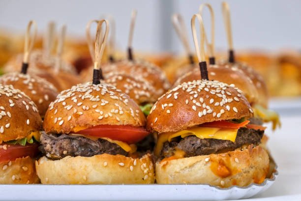 Three Halal Smash Burgers topped with cheese and bacon, presented on wooden boards.
