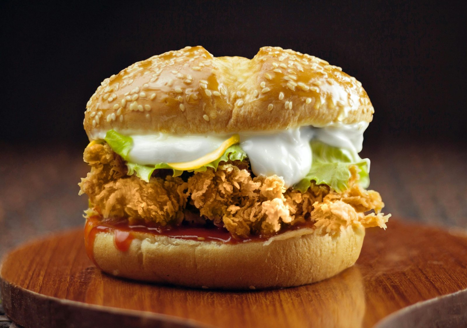 Delicious crispy chicken burger topped with fresh lettuce and creamy sauce on a sesame bun.