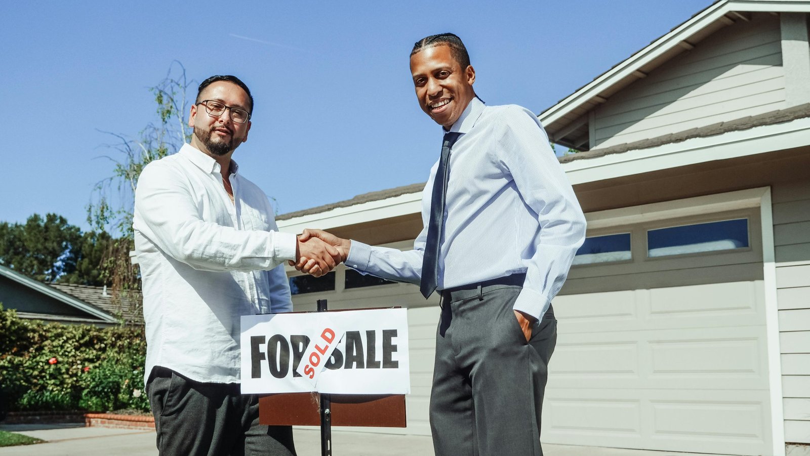 Real estate investor shaking hands with homeowner at front door
