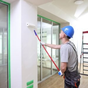 imgi_40_young-construction-worker-overalls-helmet-paints-wall-white-light-room-man-decorates_15